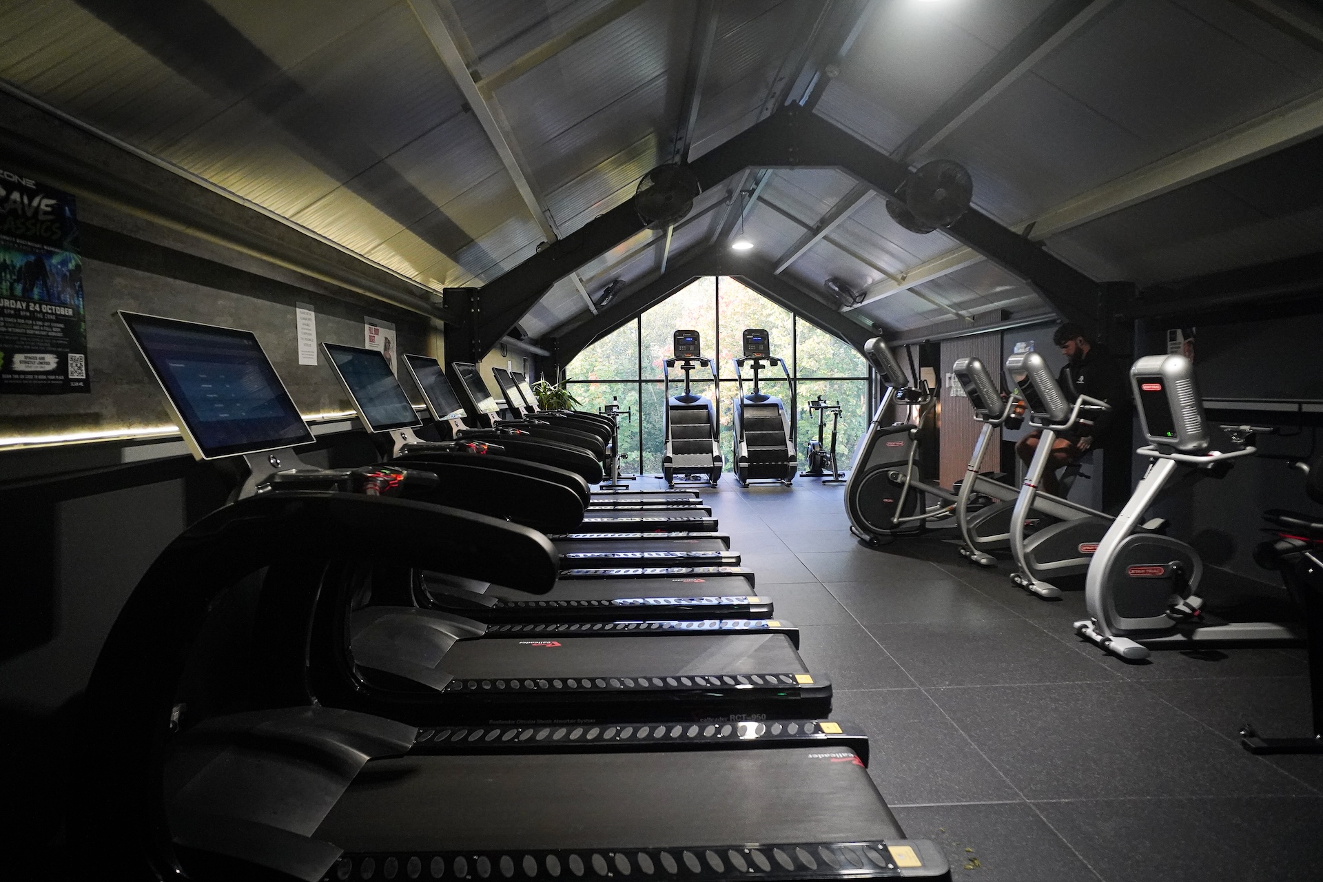 Cardio machines facing the large gable window