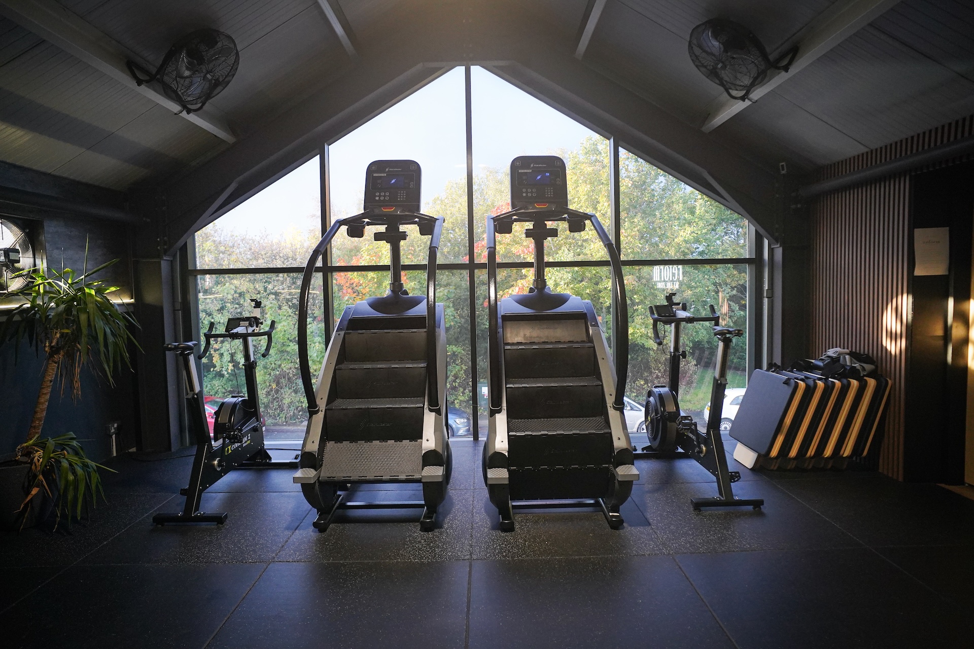 Cardio machines facing the large gable window