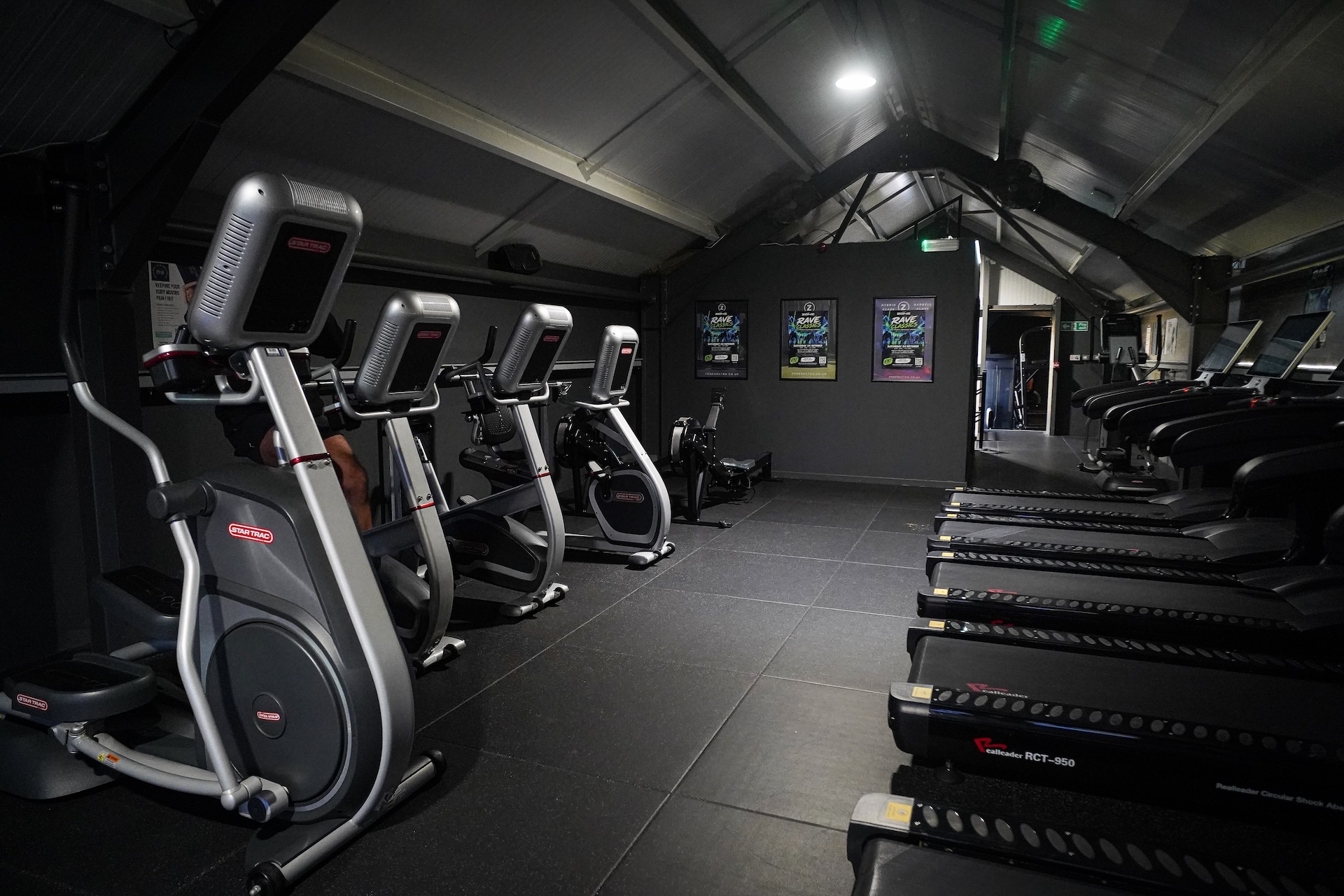Cardio machines facing the large gable window