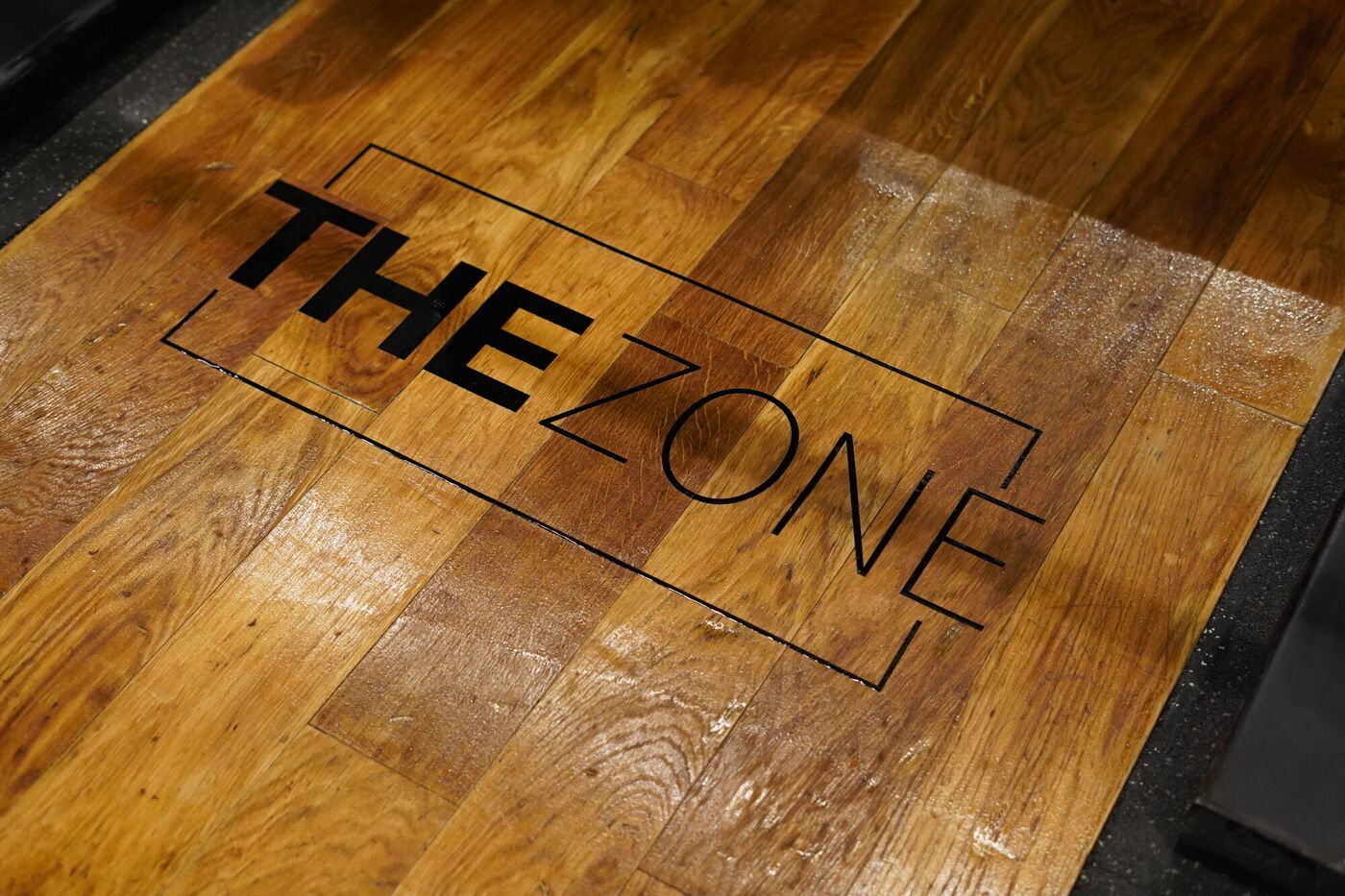 The Zone logo on a wooden lifting platform