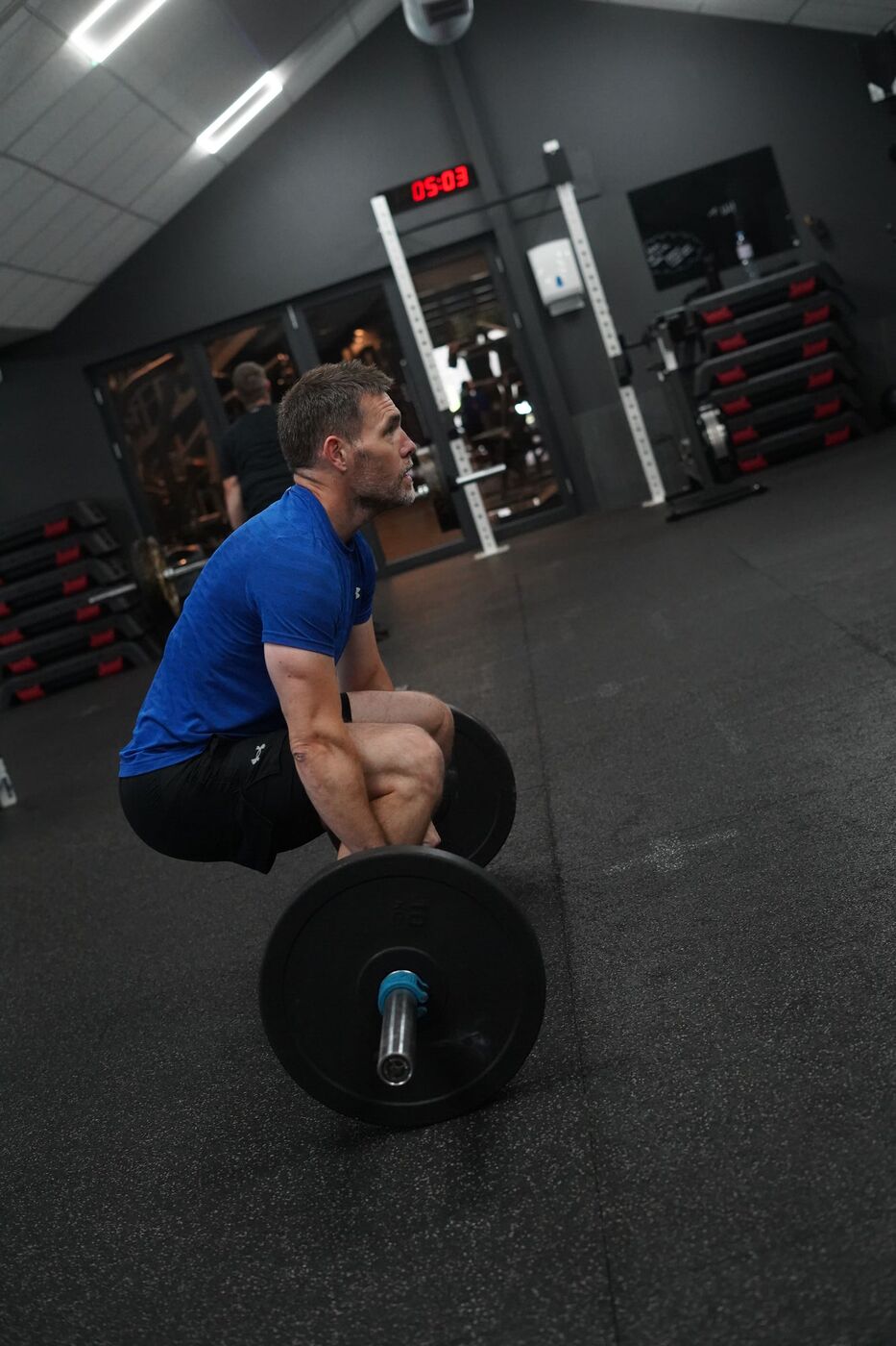 Member lifting a barbell from the floor